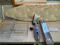 Overall view showing ironing board, baskets, iron, vacuum, towel bar