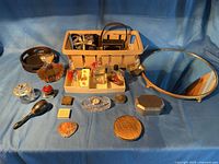Overall lot layout showing perfumes, clock, mirror, compacts, brush, jars, basket of jewelry boxes