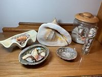 Overview of shells, plastic clam, conch, abalone bowls, glass jars