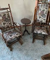 Pair of glider rockers with side table on carpet