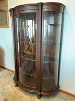 Full view of dark wood display cabinet with curved glass panels