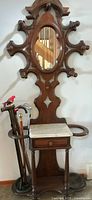 Full view of hall tree showing mirror, marble shelf, cane holders, overall design