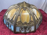 Full view of stained glass lamp shade showing amber panels, blue border, and metal filigree
