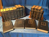 Group of 18 black hardcovers on stands and four lying flat