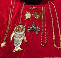 all eight jewelry items laid out on red fabric for overview