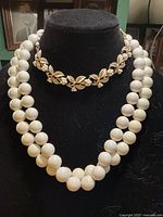 Double-strand plastic bead necklace and leaf choker on bust