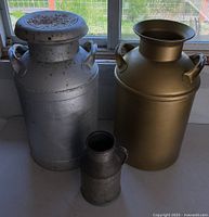Front view of three milk cans showing sizes and finishes