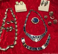 Group shot of all jewellery items laid on red fabric