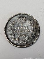 Reverse of 1907 Canada 5 cents coin showing crown, denomination, date within maple wreath