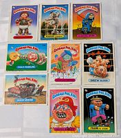 All nine Garbage Pail Kids cards laid out in three rows