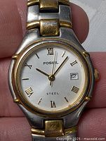 Front view of Fossil two-tone women’s wristwatch showing dial, hands, date, bezel, bracelet links
