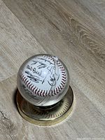 Baseball inside clear acrylic display on gold-tone base