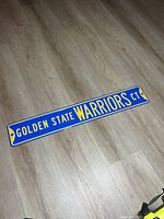 Front view of entire Golden State Warriors street sign on floor