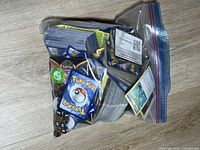 Full view of zipper bag with bulk Pokémon cards, dice and accessories