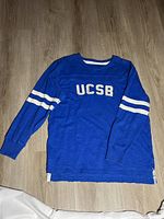 Full view of blue UCSB long sleeve shirt on floor