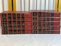 Two vertical stacks showing full 38-volume set, uniform red leather with gilt details