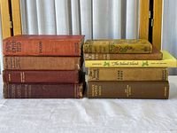 Two stacks of eight vintage cloth-bound books showing covers and spines