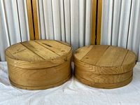 Pair of round wooden storage bins side by side showing exterior