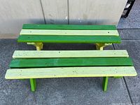 Two green and yellow wooden benches viewed from front/top