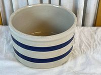 Angled exterior view showing beige body and two blue stripes