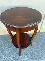 Full view of round mahogany side table showing top and lower shelf