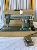 Front view of White Rotary sewing machine on case base with foot pedal visible