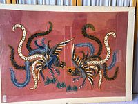 Full view of cotton batik artwork on reddish background with two mythical birds
