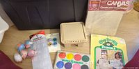 All items grouped together: latch-hook canvas, stencil booklet, paint set, stencil kit, brush basin, eggs, bead jars