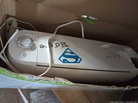 White Cricut Explore One machine partially inside original box with power cord visible