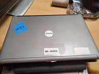 Closed Dell Latitude D630 top cover showing Dell logo and asset stickers
