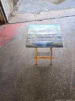 Full view of folded-out table showing painted top and wooden legs