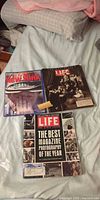 Three Life magazines laid out on bed showing covers