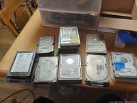 Nine of the hard drives laid out in three rows showing labels and wear