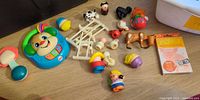 Overview of mixed Little People parts, electronic puppy toy, rattle, fences, figures, animals and flash-card pack