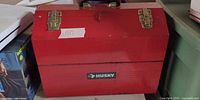 Front view of red Husky toolbox with logo, latches visible