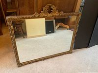Front view of mirror showing full carved gilded frame and glass