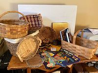 Assorted baskets, books and scattered crate labels displayed on table