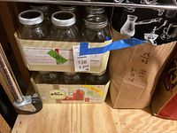 Cardboard flat holding four large canning jars