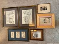 All six framed artworks laid out on carpet