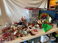 Wide view of assorted Christmas decorations, storage bins, ornaments, miniature houses, plush figures
