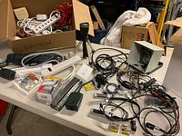 Overview of assorted power strips, cables, adapters, flashlights on table