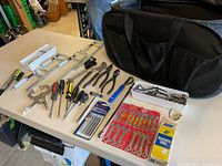 Overall lot view with bag, clamps, pliers, screwdrivers, wrench set, sharpening stone, sockets