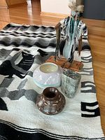 Full lot showing statuette, pottery pieces, stone carving, blanket