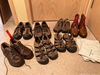 Group shot showing all seven pairs: six Keen/New Balance shoes & sandals plus Allen Edmonds boots and shoe bags