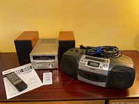 Front view of Teac MC-D80 unit with twin speakers, remote, manual, Aiwa boom box