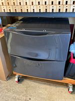 Front view of stacked smoky grey laundry pedestals on rolling base