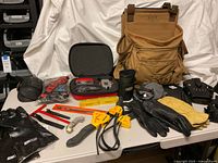 Full contents on table: Duluth bag, tool pouches, gauges, Laser Trac kit, strap wrenches, gloves, knee guards, hand tools
