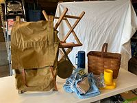 Group shot of backpack, stools, basket, canteen, thermos, picnic organizer and cups