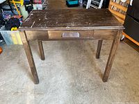 Full front view of wooden table showing drawer and overall structure