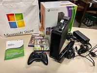 Full lot with console, Kinect sensor, controller, games, cables, box, tote bag and manual visible